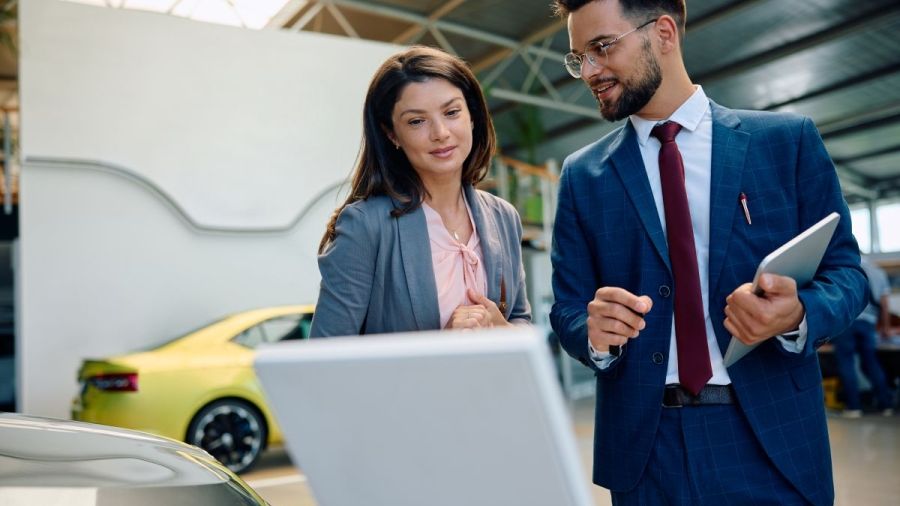 man and woman in car dealership